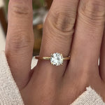 Video of a hand wearing a 14k yellow gold hidden halo diamond engagement ring