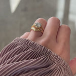 Video of hand modeling a 14k yellow gold rose-cut salt and pepper diamond, stacked with wide V-shaped wedding band