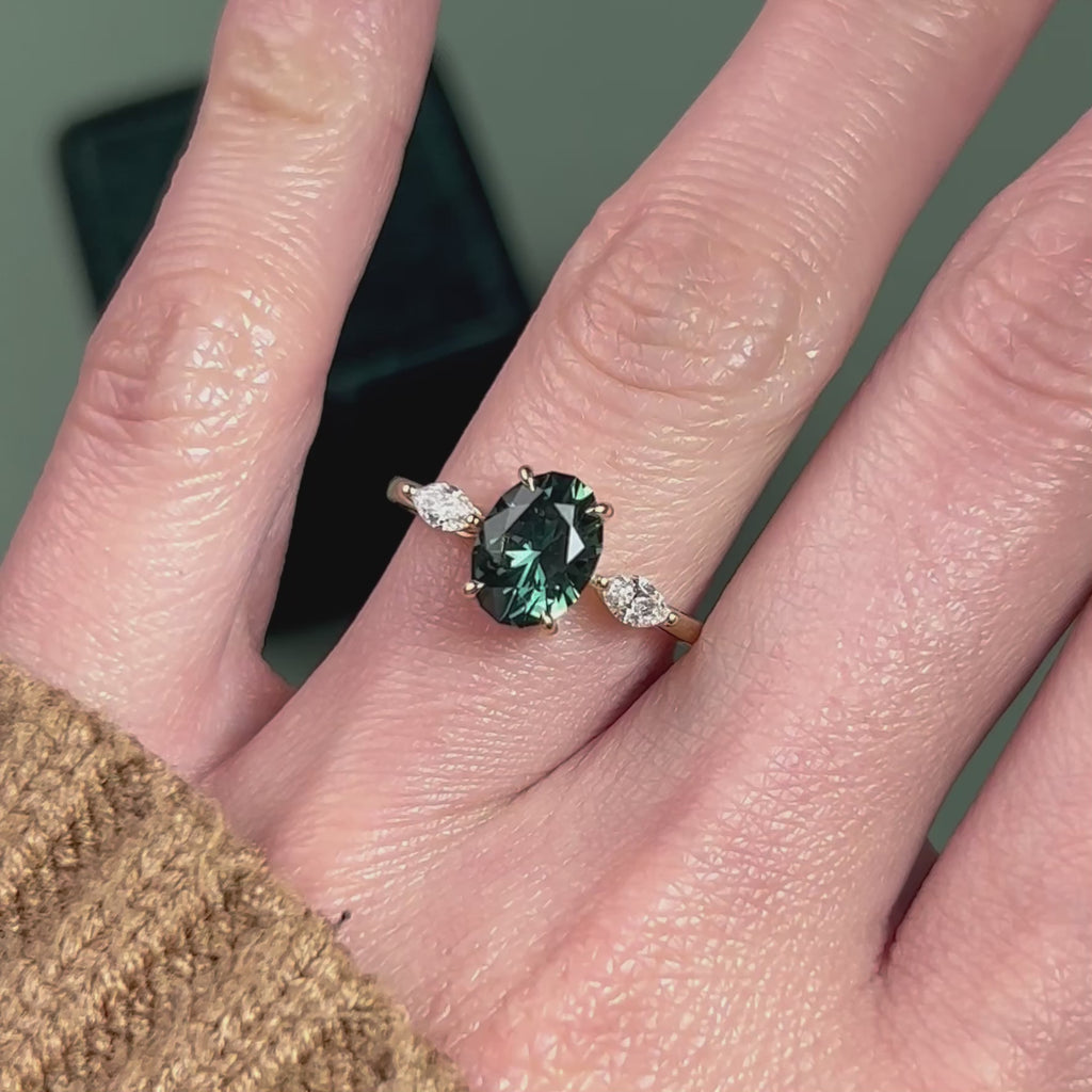 Video of a 14k yellow gold teal green oval sapphire and marquise diamond engagement ring
