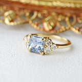 Geometric 14k yellow gold light blue sapphire engagement ring with cluster diamond accents