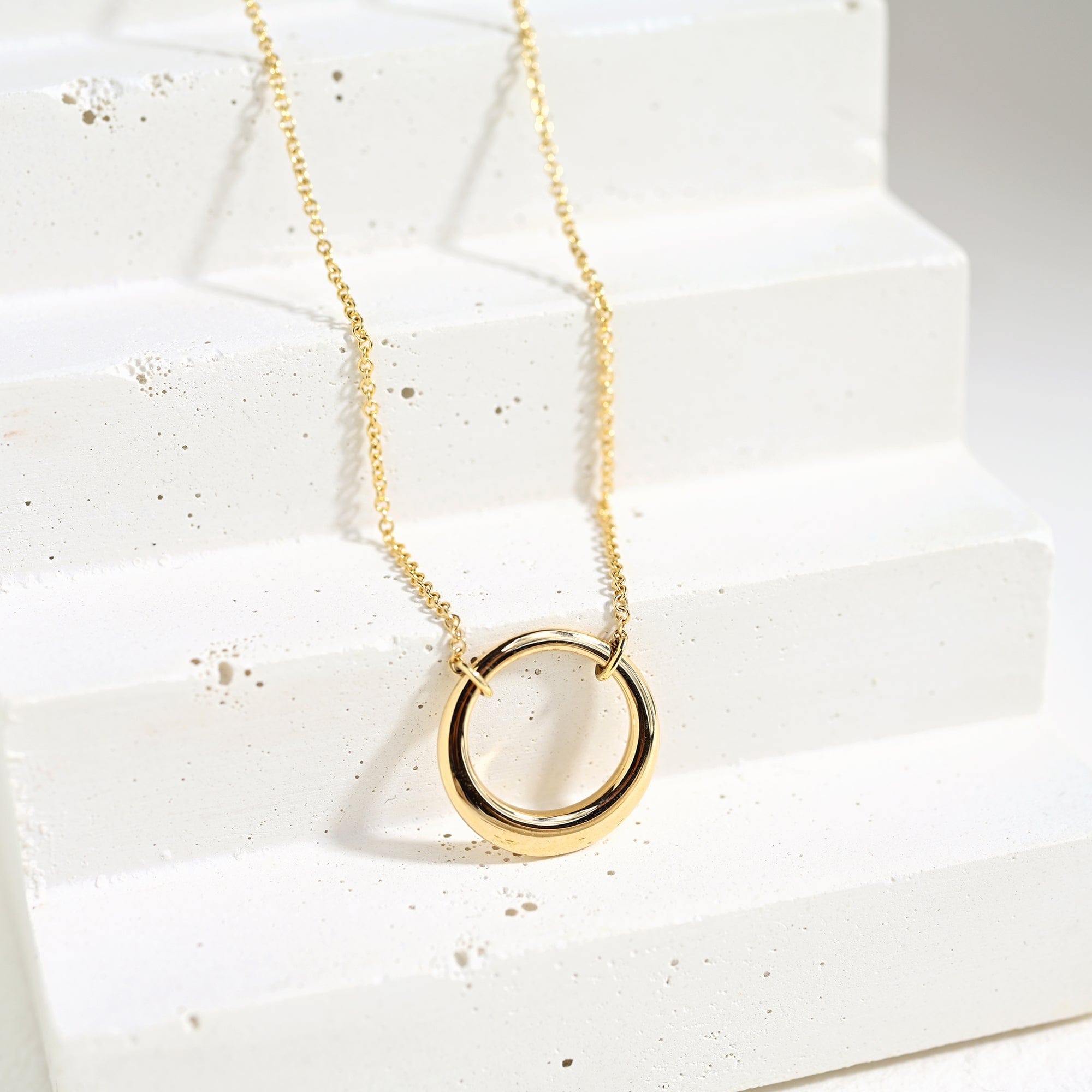gold open pendant on white background with polished edges