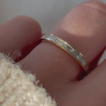 Video of a hand modeling channel set baguette diamond wedding band in 14k yellow gold