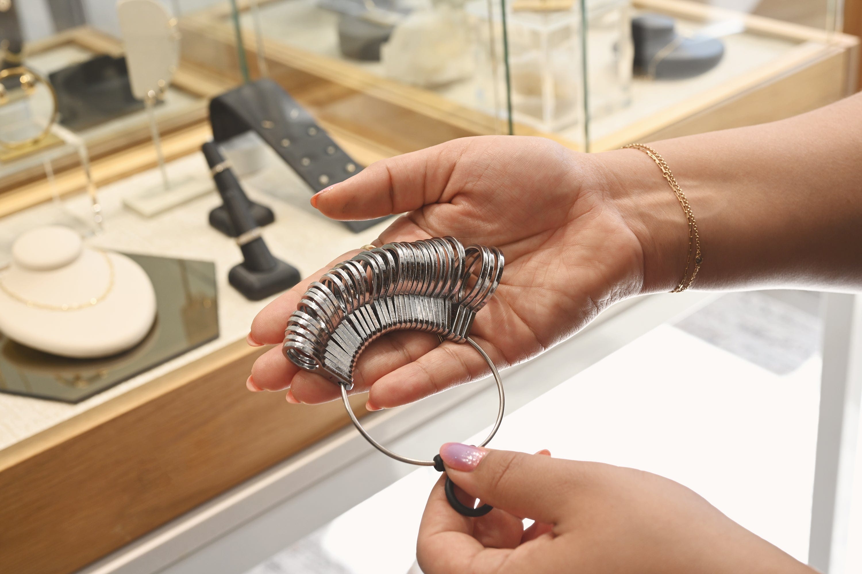 Hands holding a jeweler's ring sizer set used to measure ring size