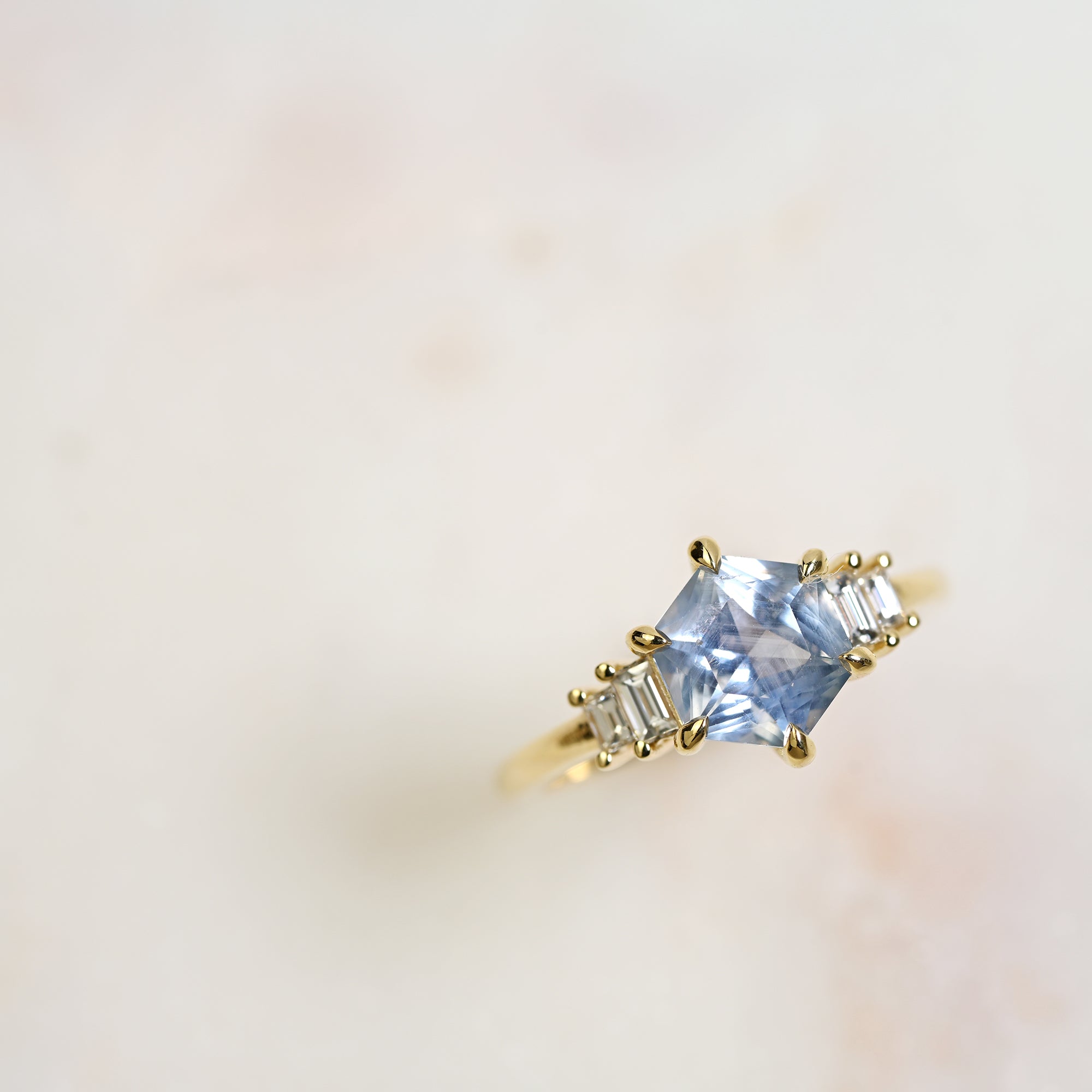 Light blue Montana hexagon sapphire engagement ring with baguette diamonds set in 14k yellow gold