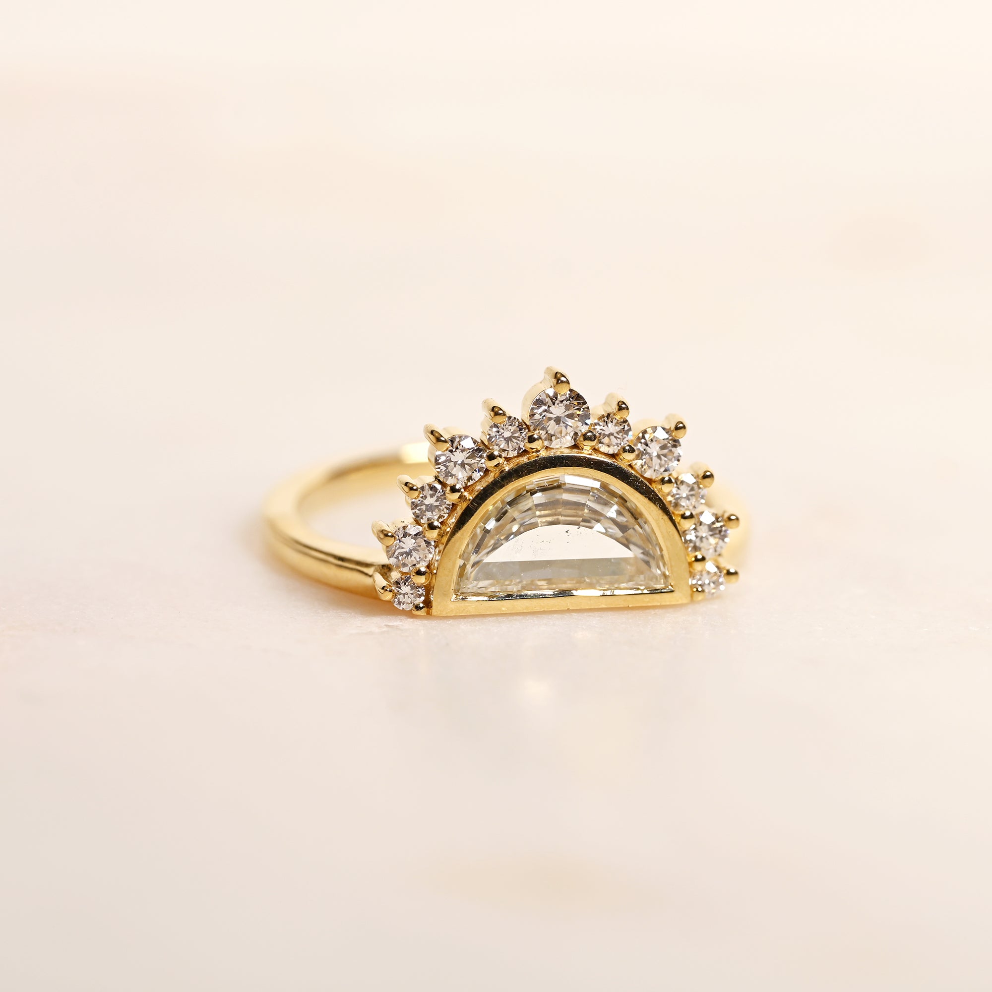Half moon diamond engagement ring in a unique 14k yellow gold halo setting