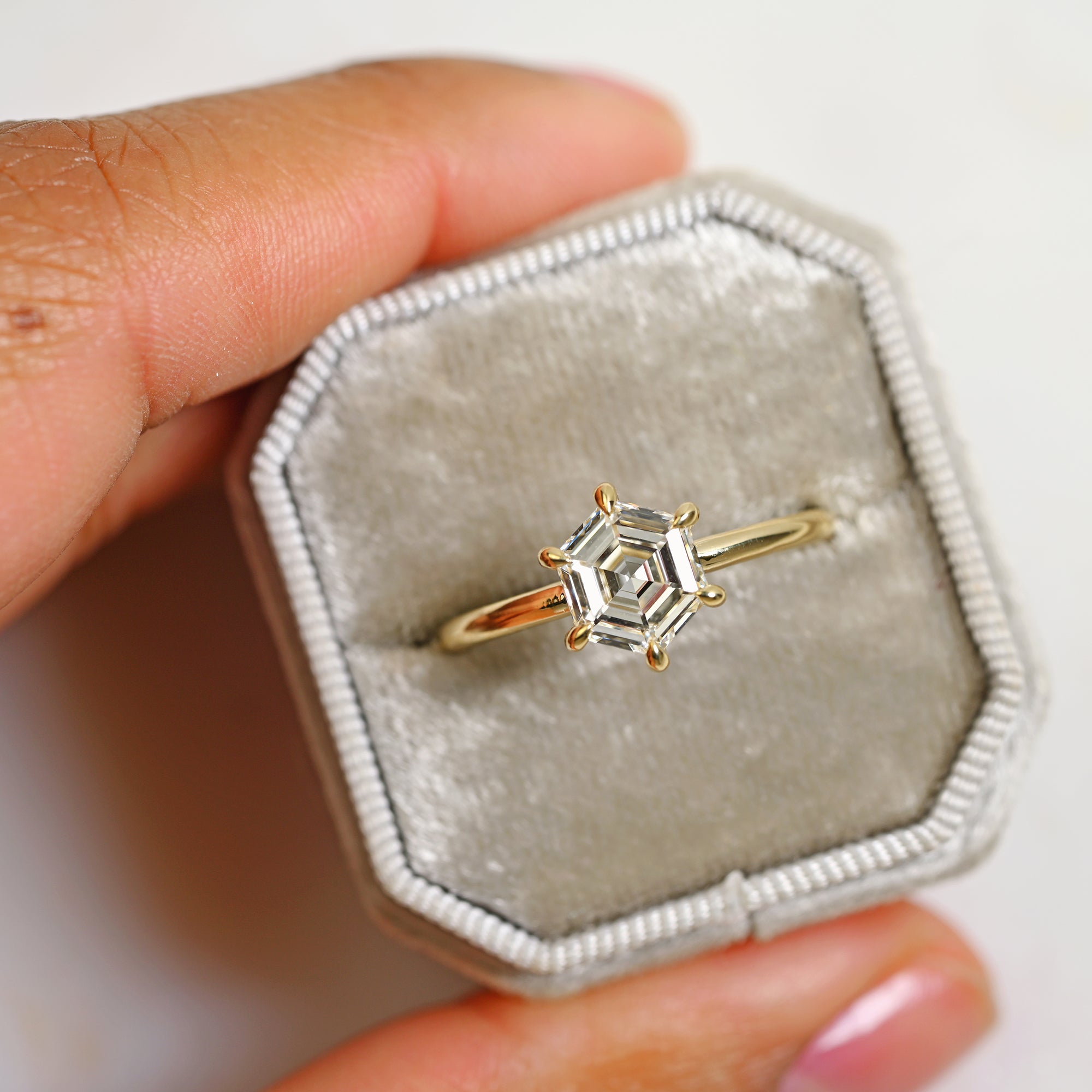 Geometric hexagon diamond engagement ring in 14k yellow gold solitaire setting with six prongs in a gray ring box