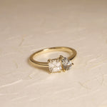 14k yellow gold Toi-et-Moi engagement ring with a white asscher cut diamond and a green pear shaped sapphire