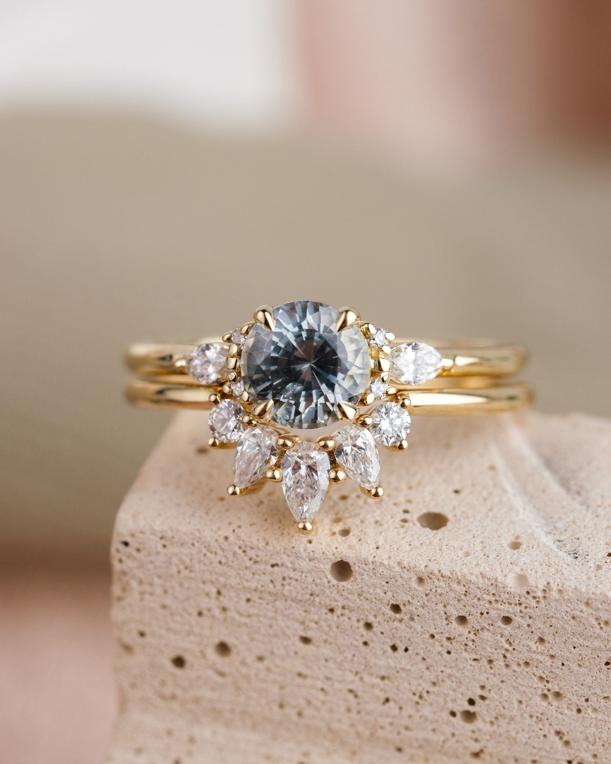 14k yellow gold engagement ring with stormy gray-blue sapphire and white accent diamonds, paired with diamond wedding band