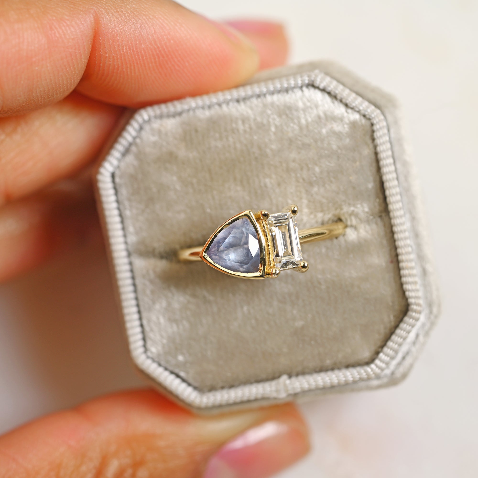 Toi-et-moi baguette diamond and light blue Montana sapphire engagement ring set in 14k yellow gold in a gray ring box