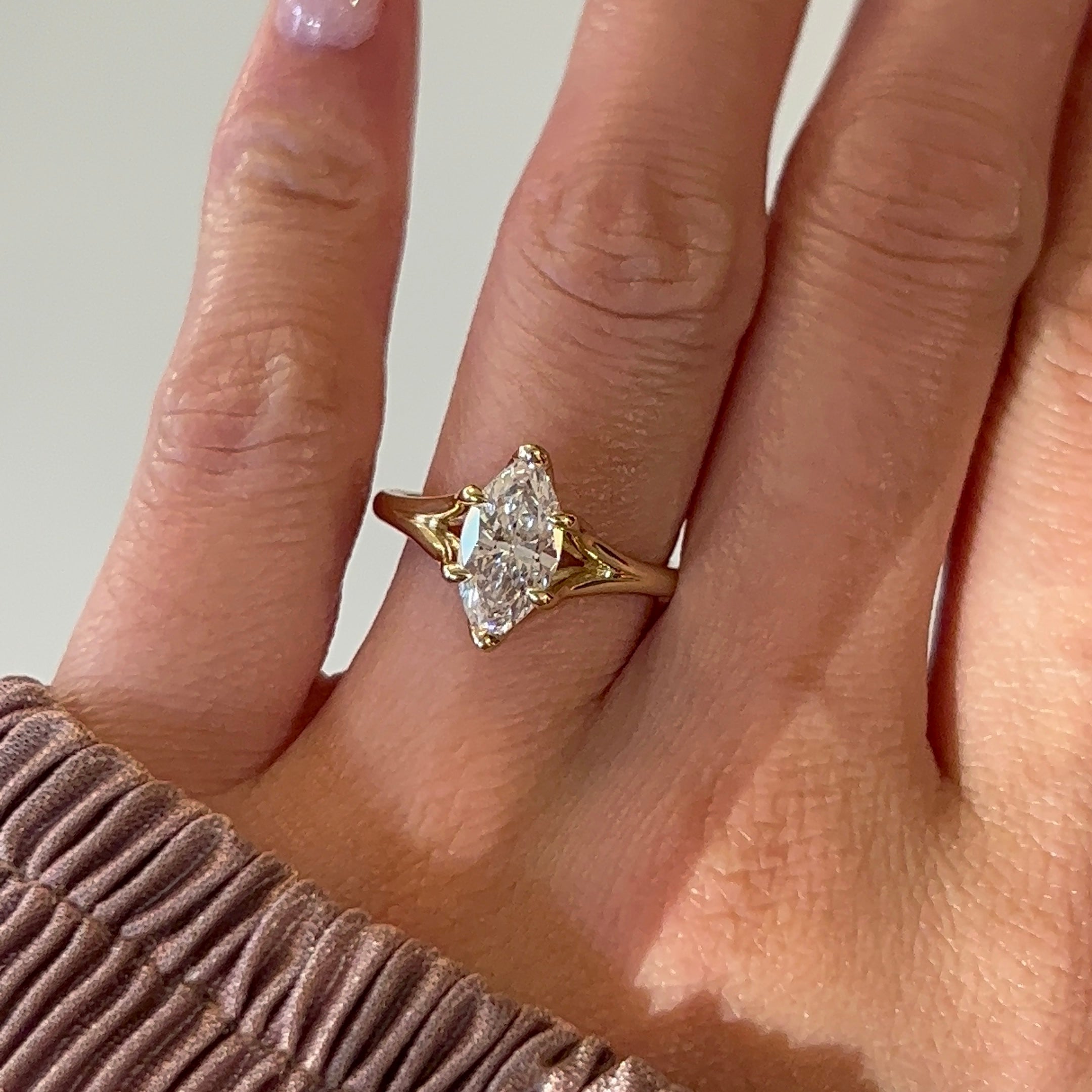 14k yellow gold marquise diamond engagement ring on a hand