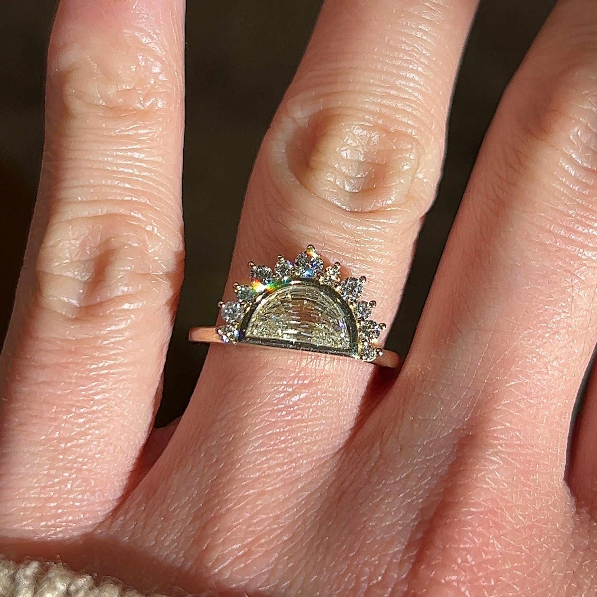Video of a Half moon diamond engagement ring in a unique 14k yellow gold halo setting on a hand