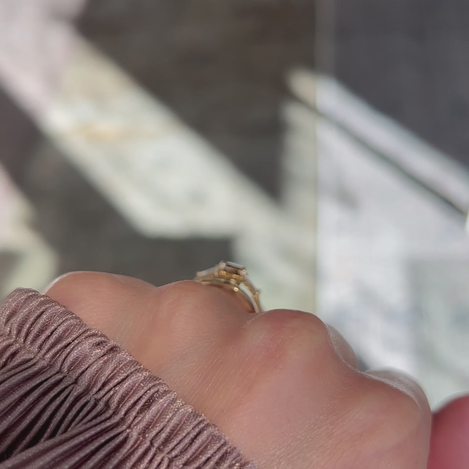 video of a 14k yellow gold engagement ring with a fancy brown cushion diamond and tapered baguette diamond accents worn with a thick gold curved wedding ring