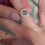 Video of a 14k yellow gold engagement ring with a round purple sapphire and double halo of diamonds worn on a hand