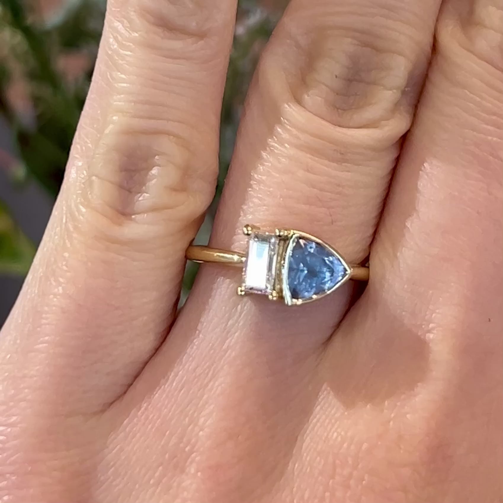 Video of Toi-et-moi baguette diamond and light blue Montana sapphire engagement ring set in 14k yellow gold on a hand
