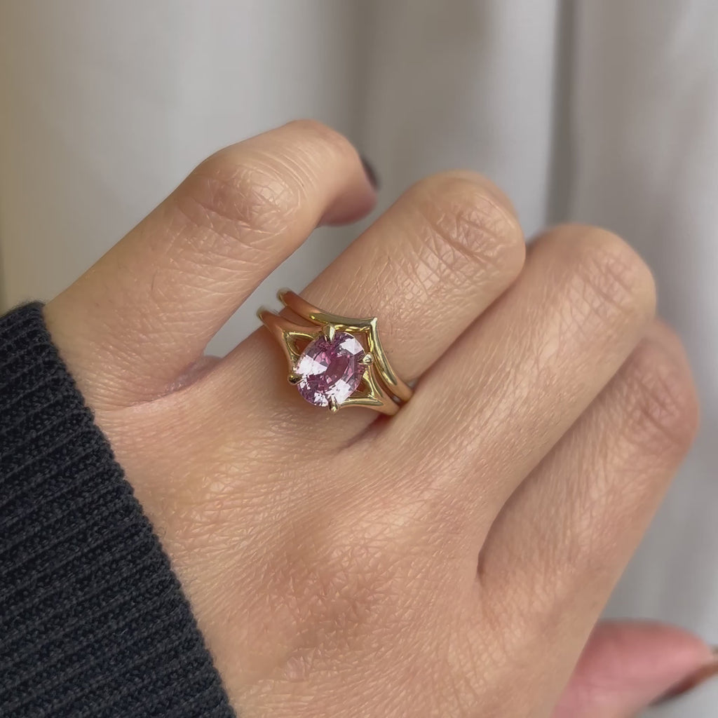 Video of a pink sapphire 14k yellow gold split shank engagement ring paired with a matching yellow gold wedding ring 