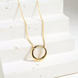 gold open pendant on white background with polished edges