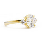 Zara Oval Three Stone Moissanite Engagement Ring viewed from the side in yellow gold